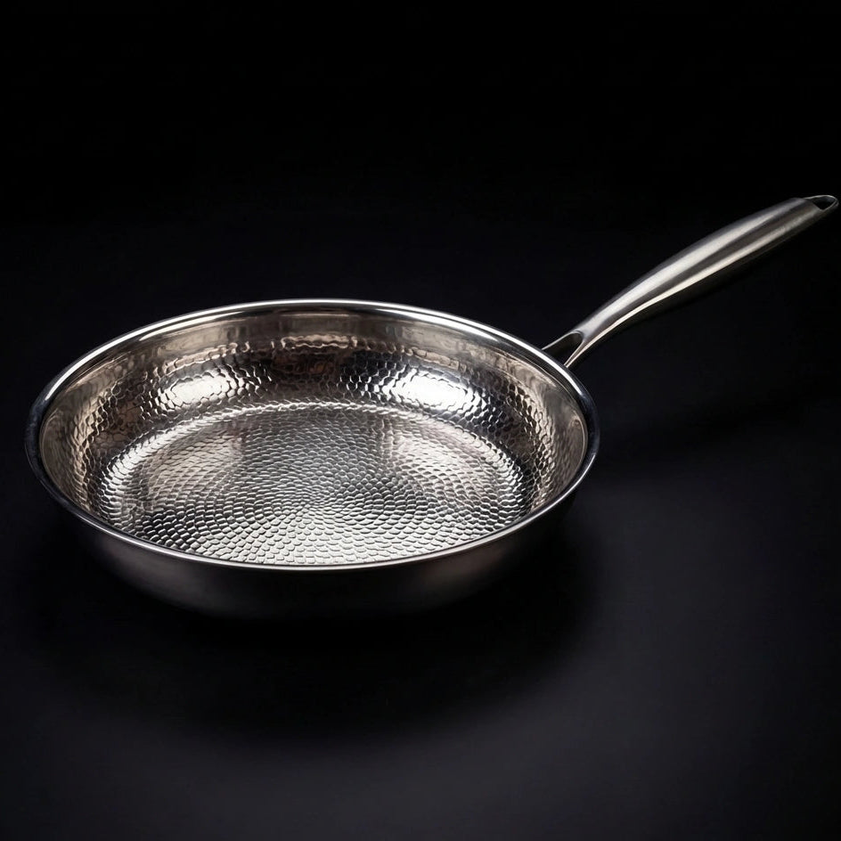 Hand-hammered titanium frying pan searing food, naturally non-stick PFAS-free cookware by Okura